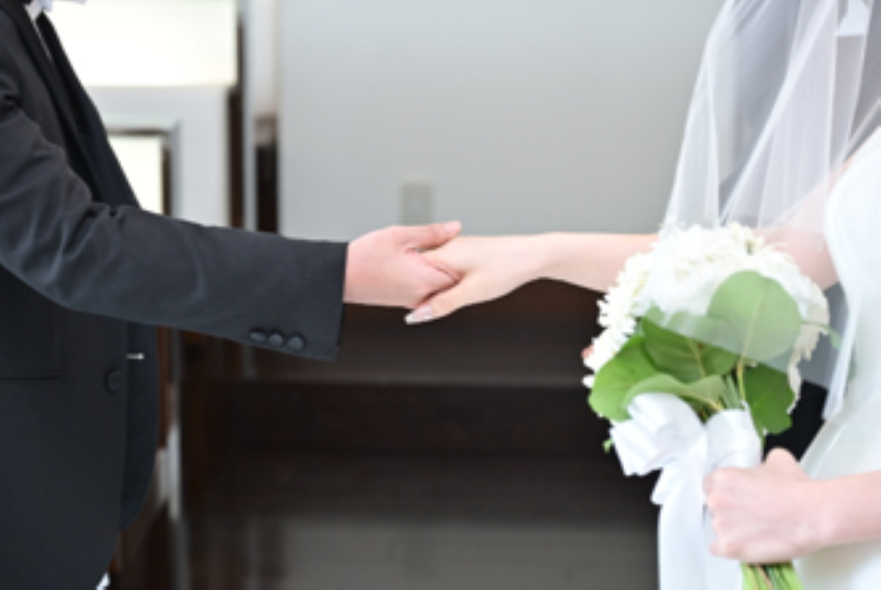 新郎新婦が手を取り合う一瞬を切り取った、あたたかみあふれるウェディングシーン。軽井沢の結婚式場で叶えるナチュラルで心温まる挙式の魅力を感じられる一枚です。少人数婚やアットホームな結婚式をご検討の方にもおすすめのスタイルです。