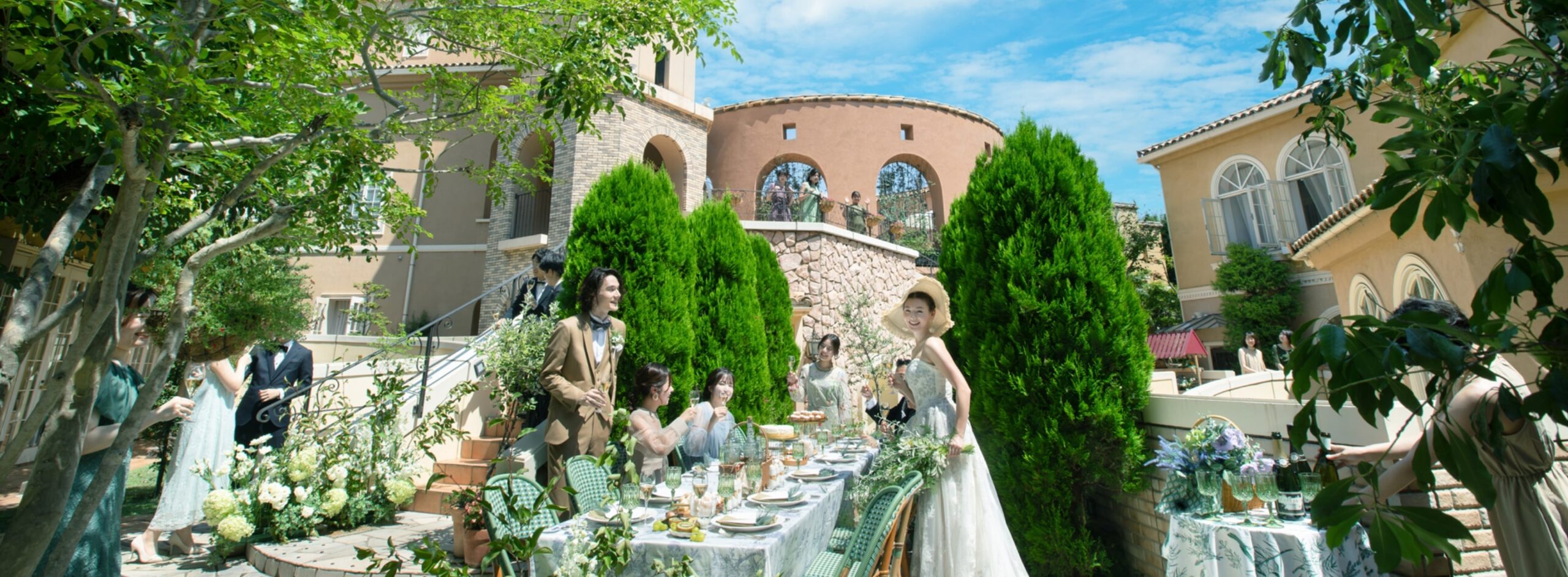 さいたま市の結婚式場アネーリ大宮。青空の下、緑溢れる南欧風ガーデンでゲストと楽しむパーティ。海外リゾートのような開放感あふれるウェディング風景。