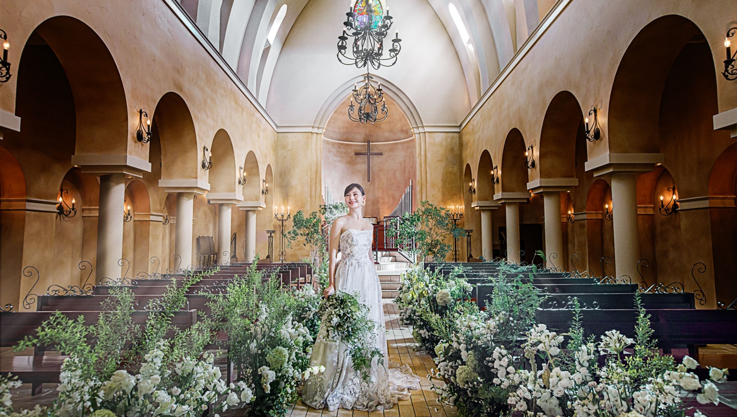 さいたま市の結婚式場アネーリ大宮。緑と花々が彩る森のような大聖堂。天井の高いチャペルに光が降り注ぎ、ドレス姿の花嫁を美しく照らす幻想的なフォト。