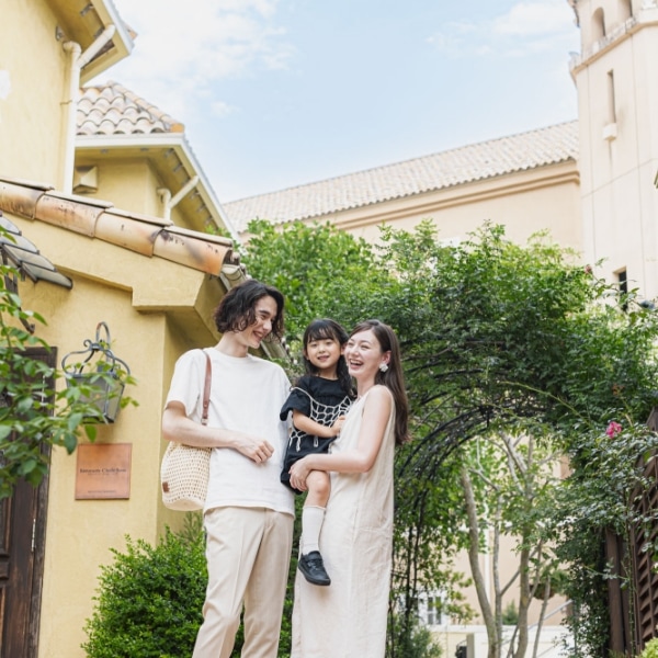さいたま市の結婚式場アネーリ大宮「ノス・ド・フロマン」。南欧風の中庭で記念日を祝う家族3人。結婚式後も思い出を重ねる、温かい再訪のひととき
