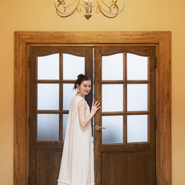 さいたま市の結婚式場アネーリ大宮「ノス・ド・フロマン」。記念日に再訪し、思い出の会場の扉を開ける女性。幸せな記憶が蘇る、特別な一日の始まり。