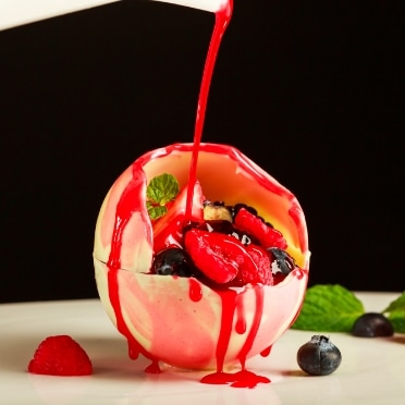 さいたま市の結婚式場アネーリ大宮。ホワイトチョコに温かいベリーソースをかけるデザート演出。とろりと溶ける甘い香りが広がる、五感で楽しむ婚礼スイーツ。