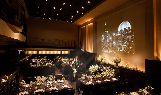さいたま市の結婚式場アネーリ大宮。夜景の映像とキャンドルが彩るシックな会場。ブラックドレスが映える、映画のような大人のナイトウェディング。
