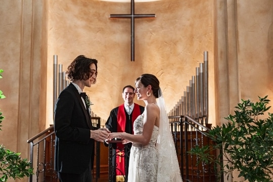 さいたま市の結婚式場アネーリ大宮。パイプオルガンが荘厳な大聖堂で、牧師に見守られ指輪を交換する二人。神聖な空気の中で愛を誓う感動のチャペル挙式。