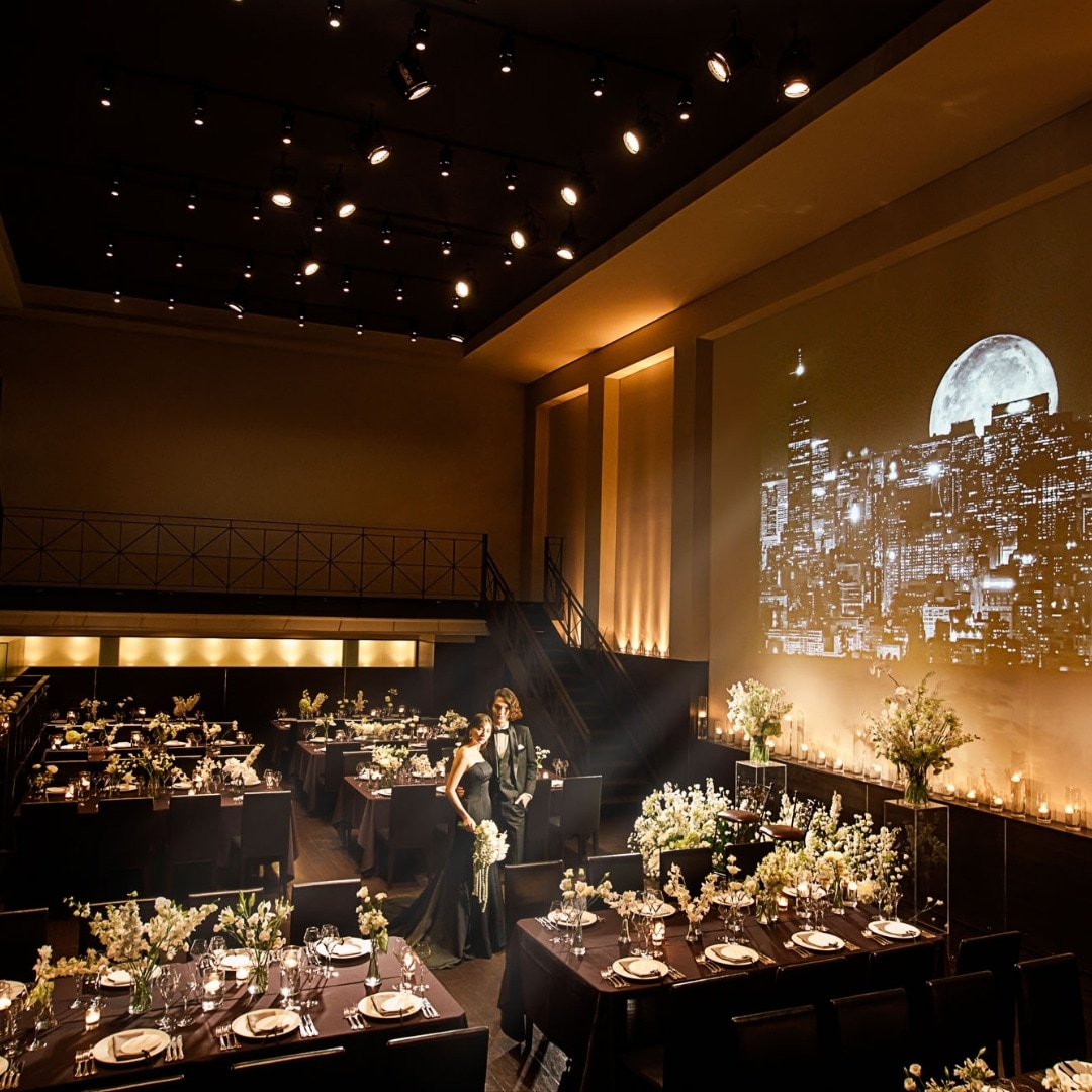 さいたま市の結婚式場アネーリ大宮。夜景の映像とキャンドルが彩るシックな会場。ブラックドレスが映える、映画のような大人のナイトウェディング。