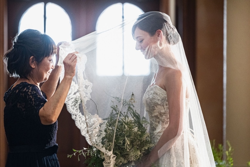 さいたま市の結婚式場アネーリ大宮。チャペルでの挙式前、母から花嫁へ最後の身支度となるベールダウン。親子の絆と感謝が溢れる感動の瞬間。