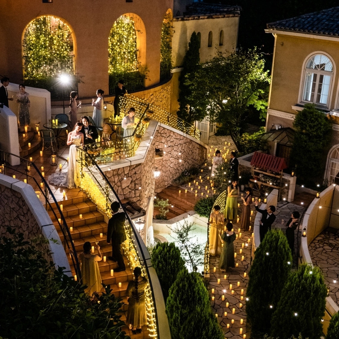 さいたま市の結婚式場アネーリ大宮。無数のキャンドルが階段とガーデンを彩る幻想的なナイトウェディング。映画のような世界観でゲストと楽しむ非日常的な夜。