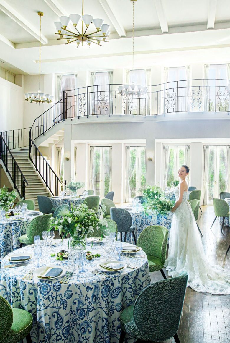 さいたま市の結婚式場アネーリ大宮。自然光が注ぐ白亜のパーティ会場。憧れの大階段とナチュラルな装飾が映える開放的な空間に佇む花嫁