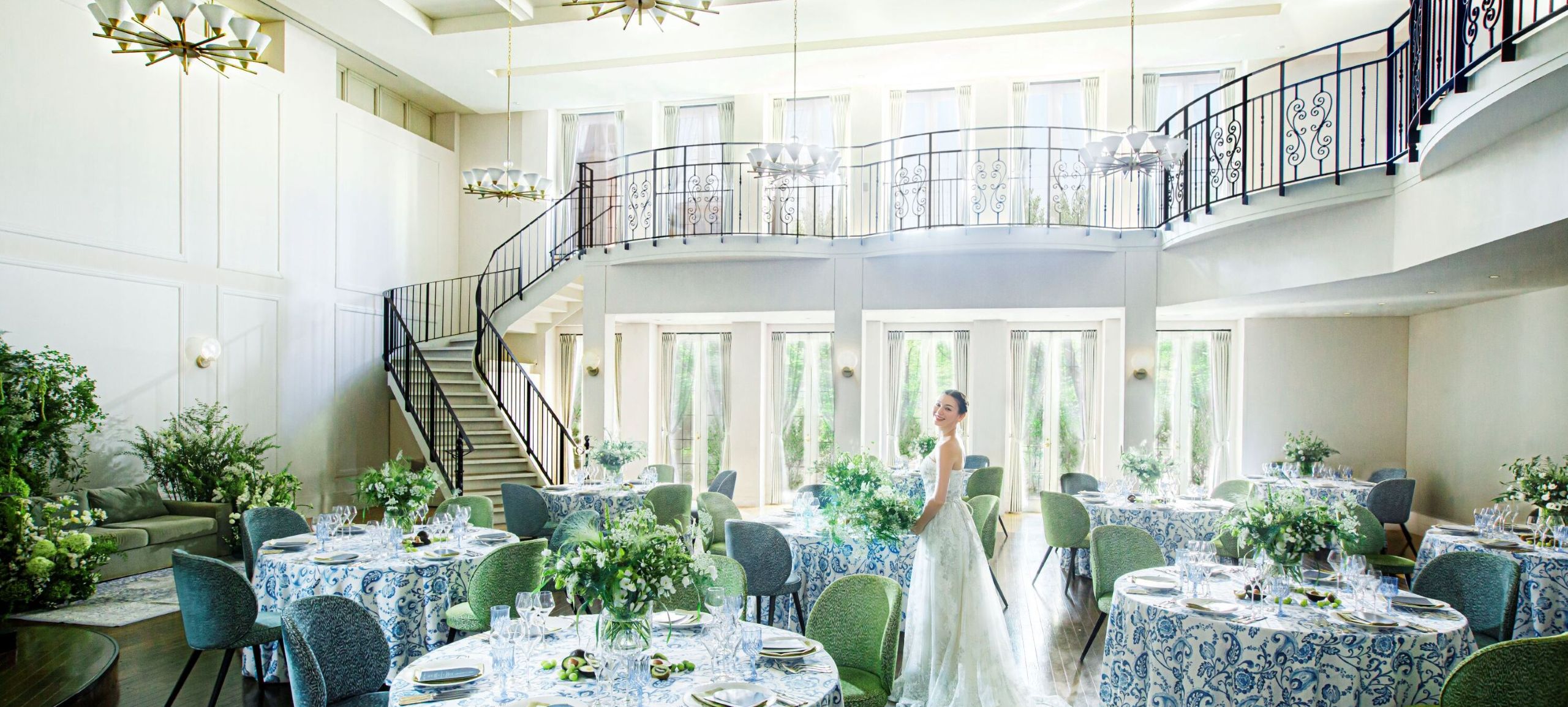 さいたま市の結婚式場アネーリ大宮。自然光が注ぐ白亜のパーティ会場。憧れの大階段とナチュラルな装飾が映える開放的な空間に佇む花嫁