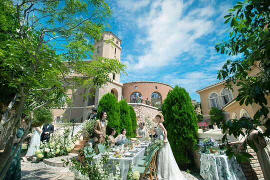 さいたま市の結婚式場アネーリ大宮。青空の下、緑溢れる南欧風ガーデンでゲストと楽しむパーティ。海外リゾートのような開放感あふれるウェディング風景。