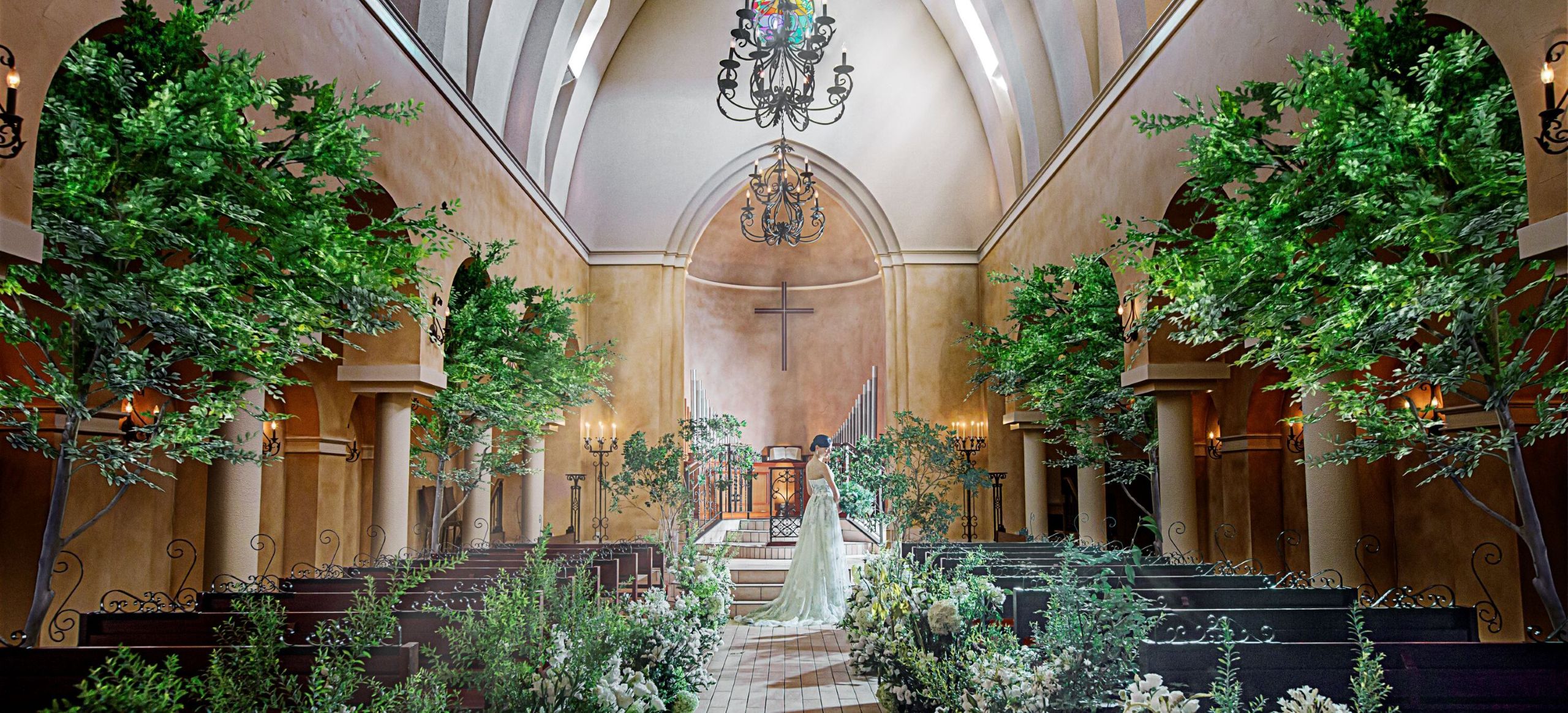 さいたま市の結婚式場アネーリ大宮。まるで森の中のような緑と自然光に包まれた幻想的な大聖堂で、ウェディングドレス姿の花嫁が佇む風景。