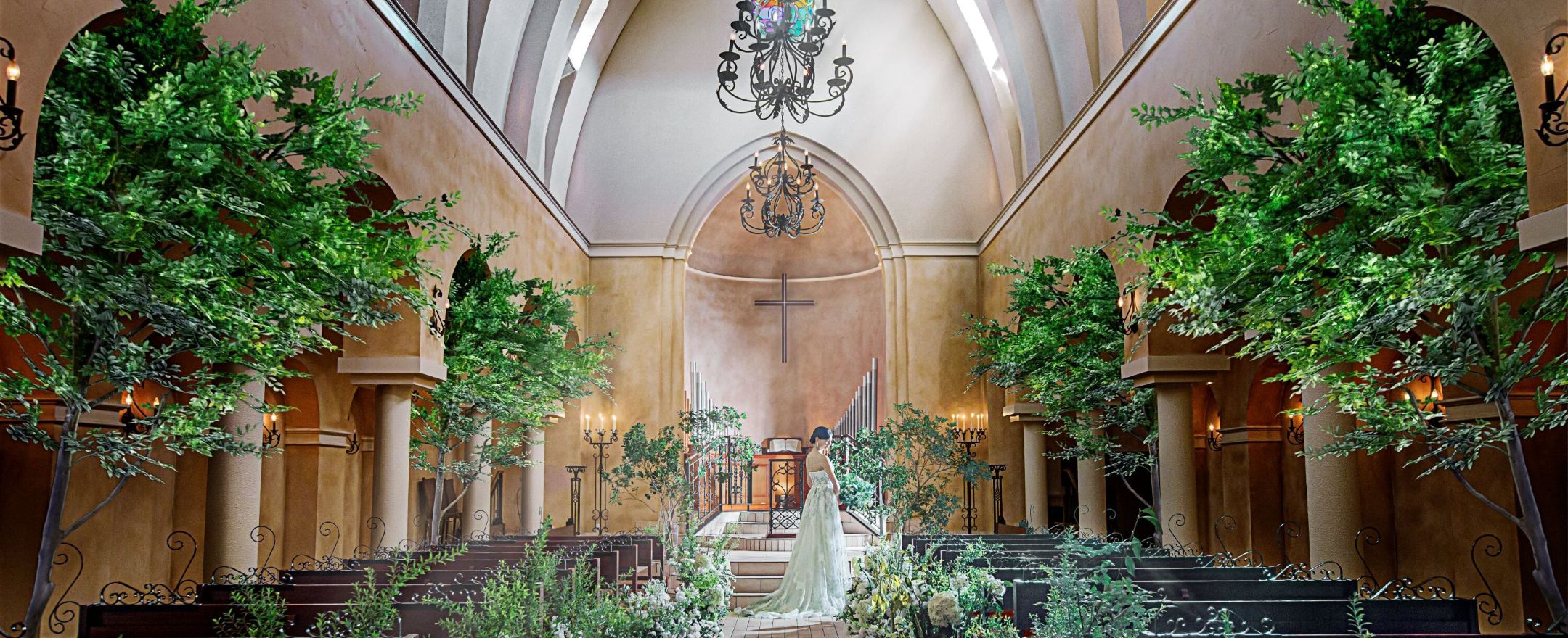 さいたま市の結婚式場アネーリ大宮。まるで森の中のような緑と光に包まれた独立型チャペル。幻想的な大聖堂でドレス姿の花嫁が佇む美しい一枚。