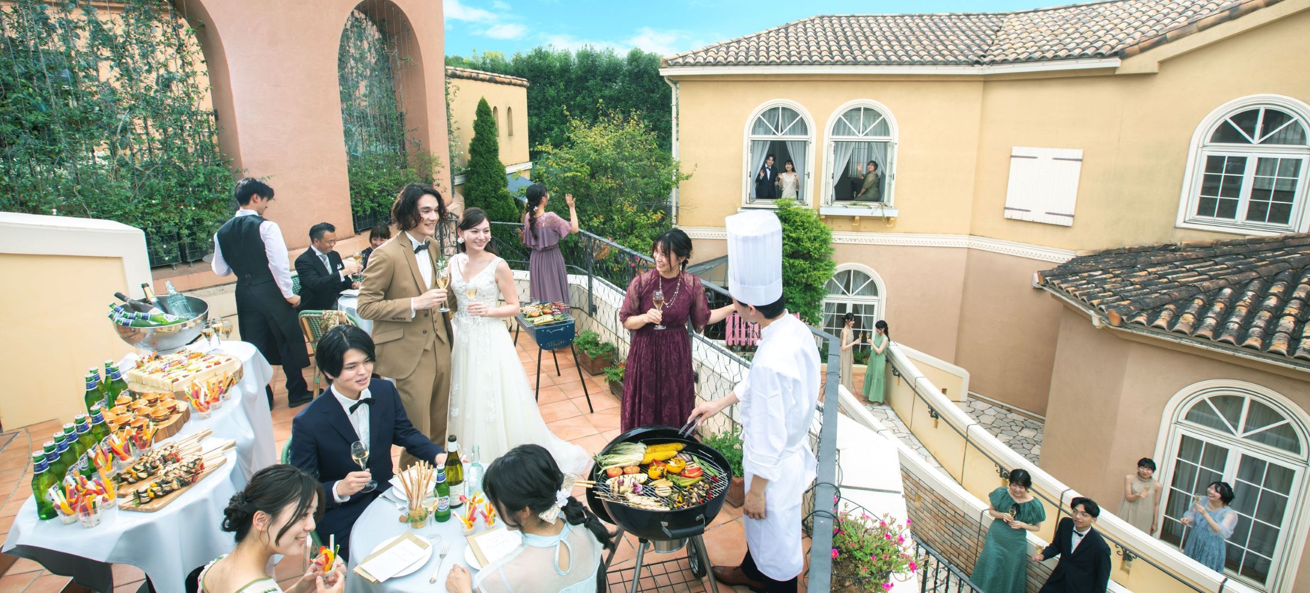 さいたま市の結婚式場アネーリ大宮。南欧風のテラスで行う開放的なガーデンパーティ。シェフのBBQ演出を囲み、ゲストと笑顔で過ごす賑やかなひととき。