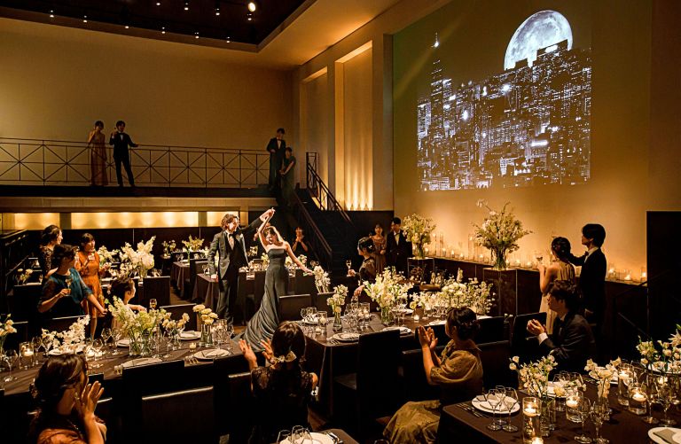 さいたま市の結婚式場アネーリ大宮。夜景の映像とキャンドルが彩るシックな会場。ブラックドレスが映える、映画のような大人のナイトウェディング。