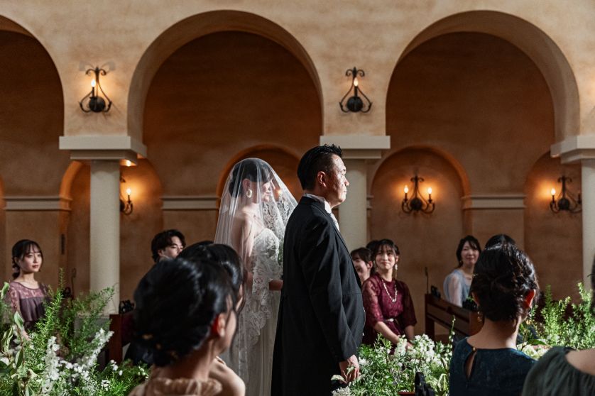 さいたま市の結婚式場アネーリ大宮。厳かな大聖堂のバージンロードを、父と共に歩む花嫁。ゲストの温かい眼差しに包まれ、感謝を胸に一歩ずつ進む感動の入場。