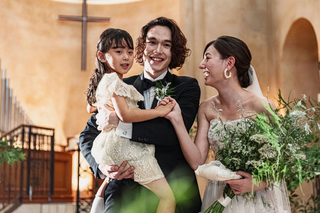 さいたま市の結婚式場アネーリ大宮。チャペルでの子連れ婚。新郎が子供を抱きしめ、新郎新婦が笑顔で愛を誓う、温かいファミリーウェディングフォト。