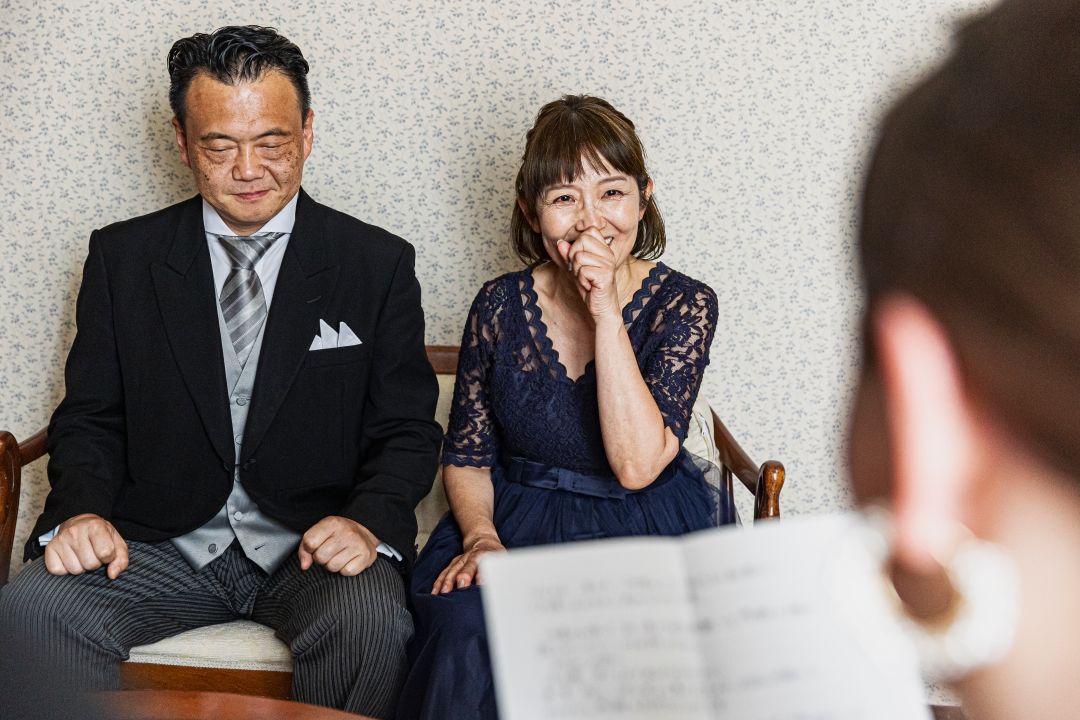 さいたま市の結婚式場アネーリ大宮。披露宴の謝辞を聞く両親の表情。感動的な手紙に涙をこらえ、我が子の成長を微笑んで見守る、温かい瞬間。