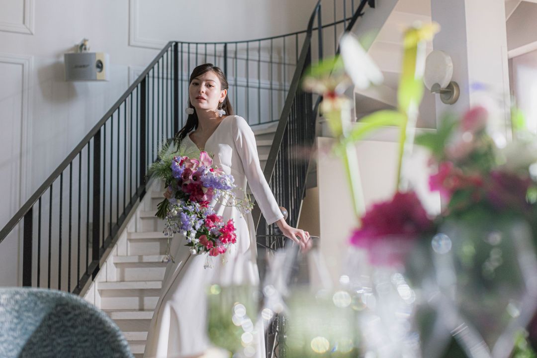 さいたま市の結婚式場アネーリ大宮。大階段に佇むウェディングドレスの花嫁。華やかなカラーブーケが映える、ドラマチックな入場シーン。