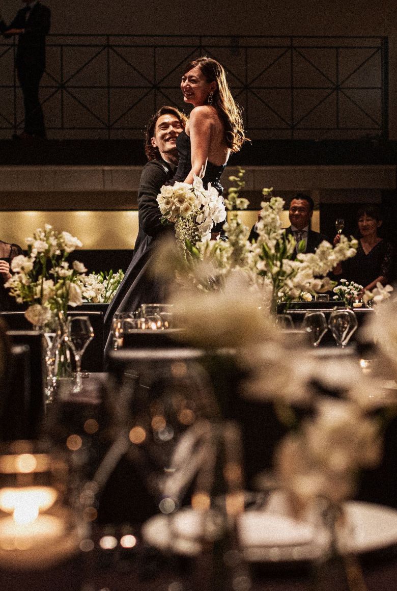 さいたま市の結婚式場アネーリ大宮。キャンドル煌めく会場で、ブラックドレスの花嫁を新郎が抱き上げる、映画のワンシーンのようなナイトウェディング。