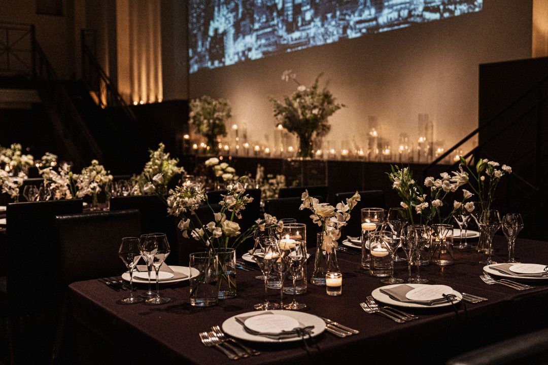 さいたま市の結婚式場アネーリ大宮。夜景の映像とキャンドルが彩る幻想的なテーブルコーディネート。洗練された大人のナイトウェディングを演出する空間。
