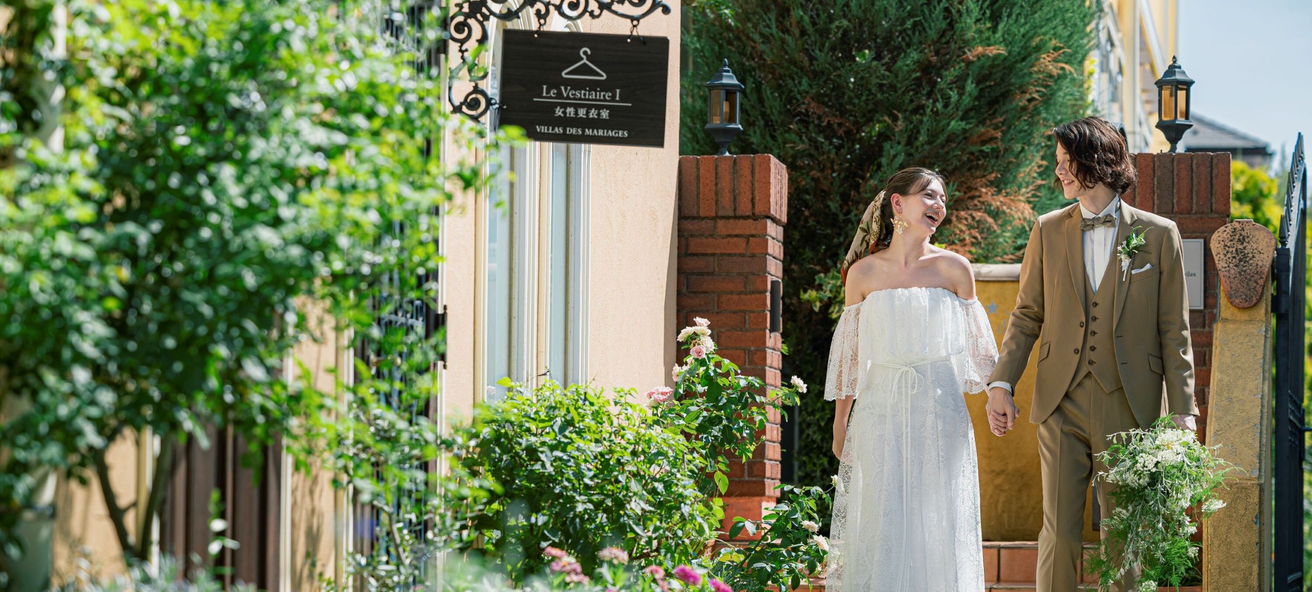 さいたま市の結婚式場アネーリ大宮。南欧風の街並みで、笑顔で手を繋ぎ散策する新郎新婦。デート気分で自然体な表情を残せるウェディングフォト。