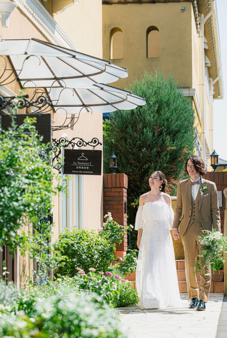 さいたま市の結婚式場アネーリ大宮。南欧風の街並みで、笑顔で手を繋ぎ散策する新郎新婦。デート気分で自然体な表情を残せるウェディングフォト。