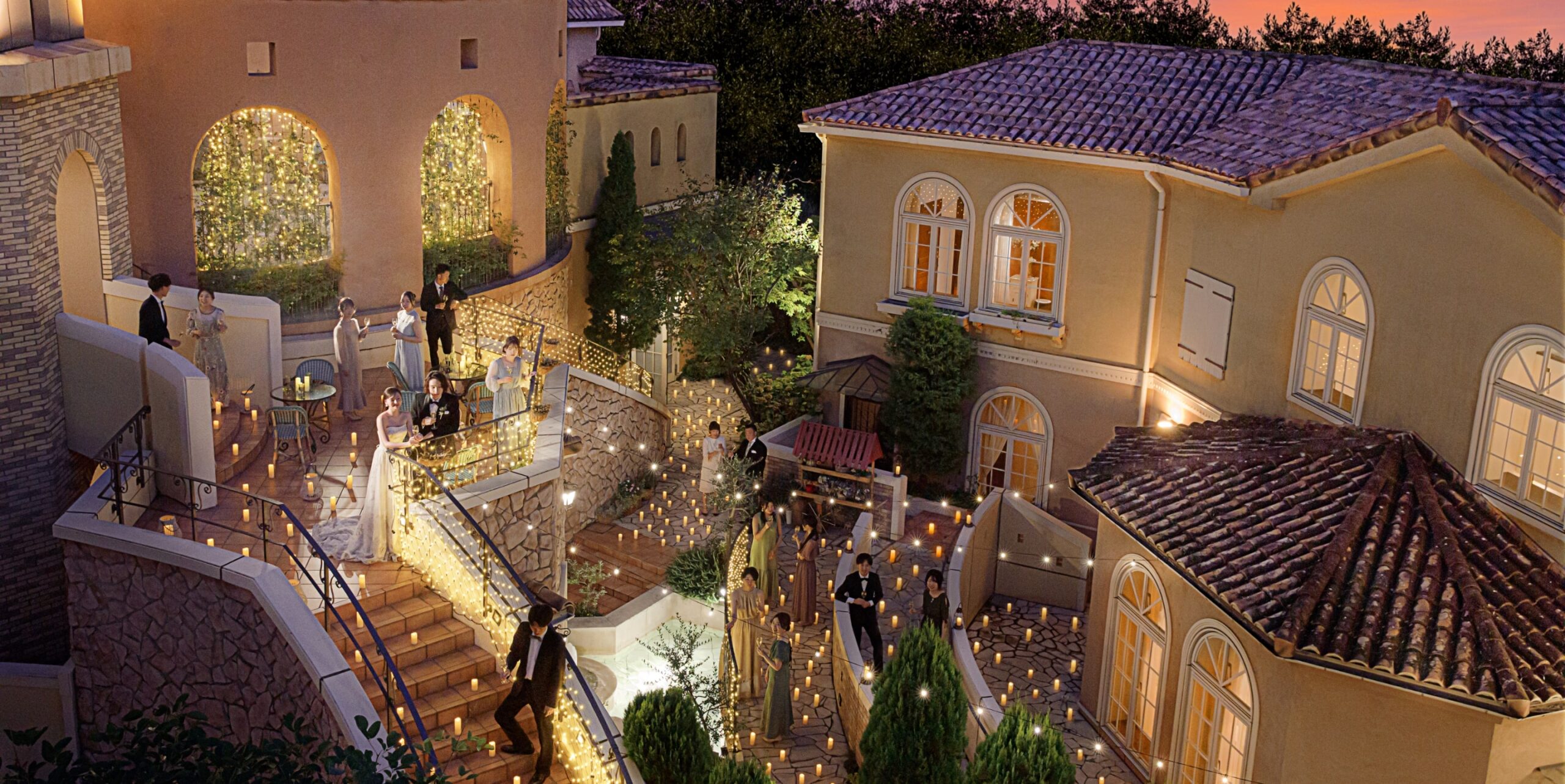 さいたま市の結婚式場アネーリ大宮。南フランス風の街並みが広がる中庭で、無数のキャンドルが輝く幻想的なナイトウェディングのパーティ風景