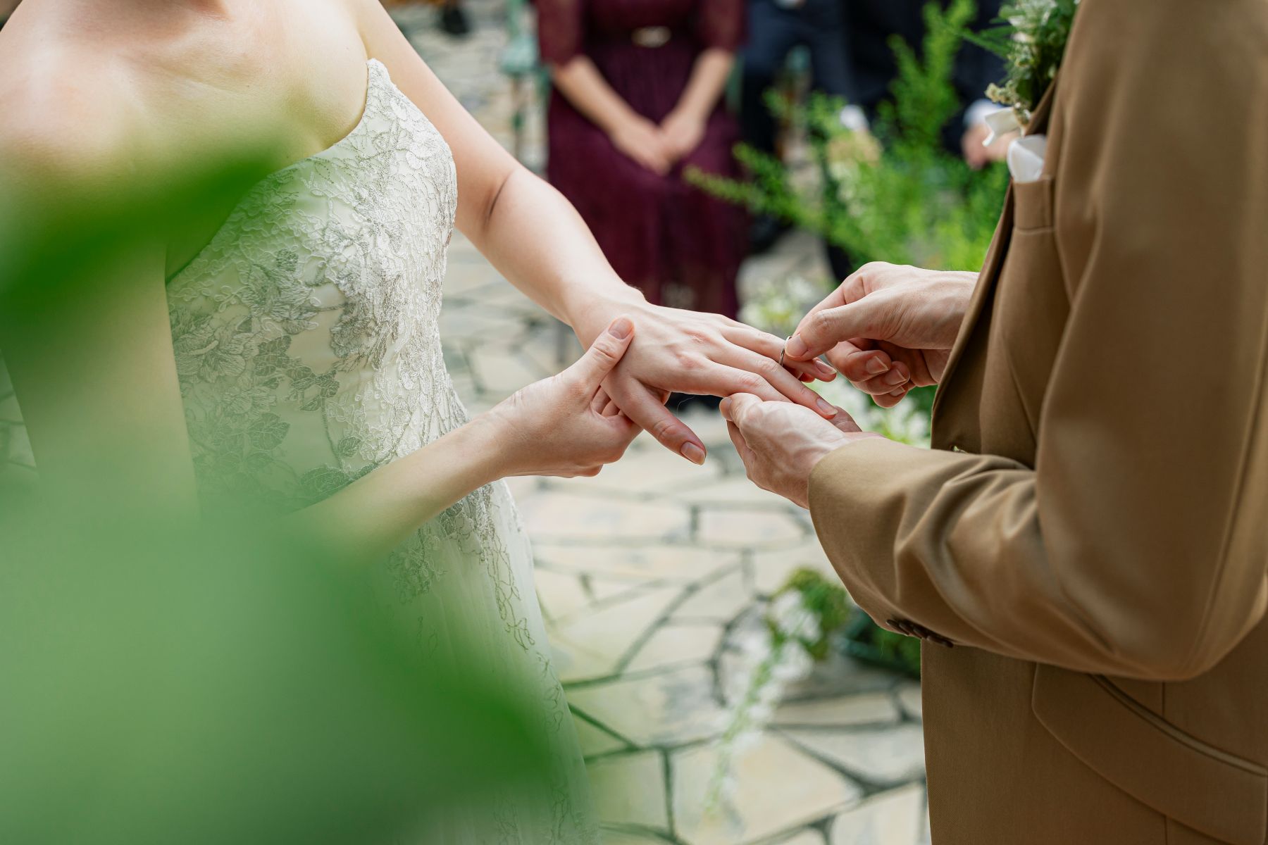 「アネーリ大宮のガーデン人前式で行われる、指輪交換の感動的なクローズアップ。自然光が降り注ぐ屋外チャペルで、ゲストに見守られながら永遠の誓いを交わす瞬間を捉えたウェディングフォト。」