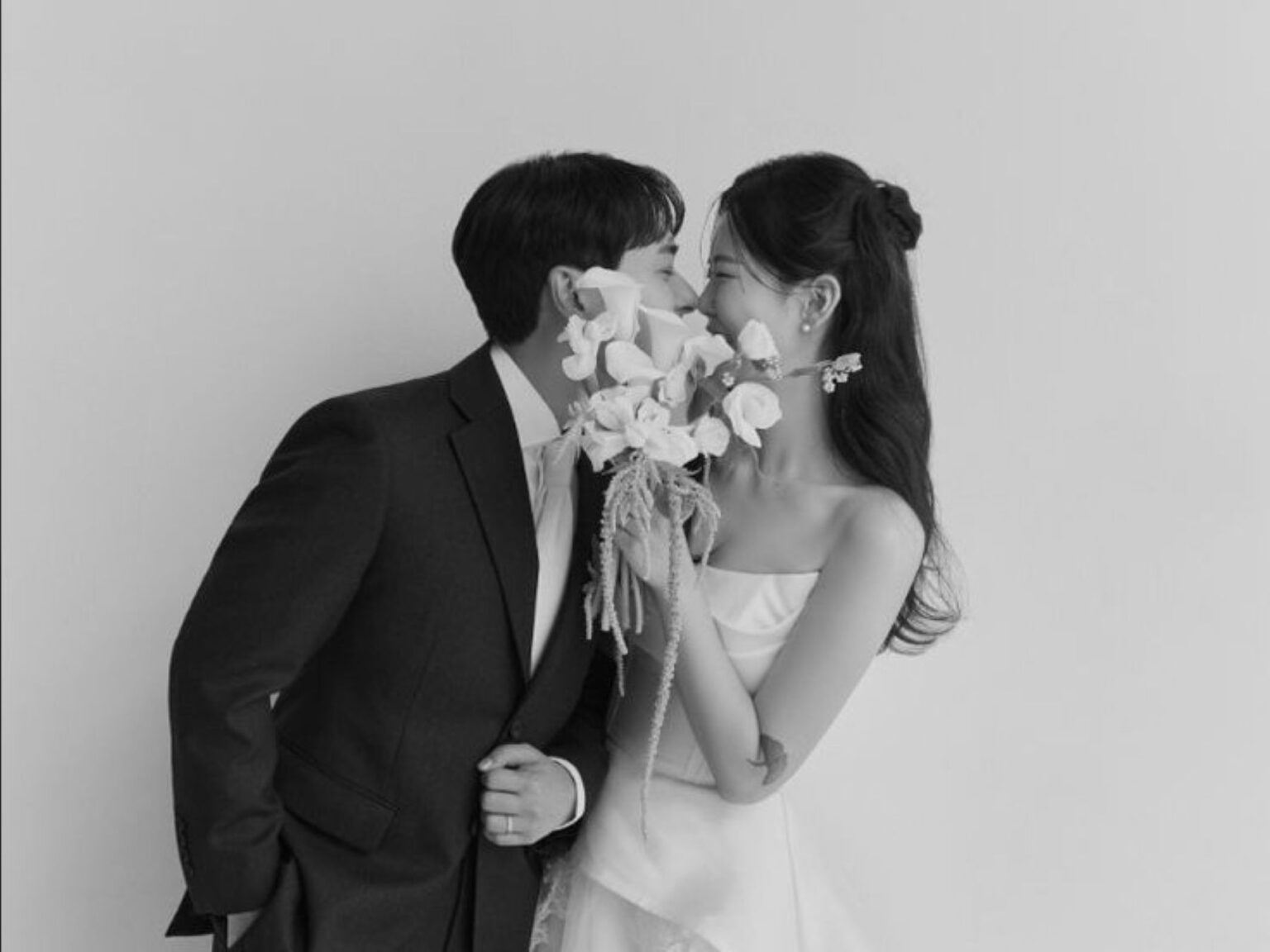 【さいたま市結婚式場アネーリ大宮】にて、モノクロ写真でロマンチックなポーズを披露する新郎新婦様。さいたま市にある市の式場で叶える、洗練されたフォトウェディングを詳細に描写しており、さいたま市内での結婚式らしい、品格と芸術性を感じさせる特別な瞬間を表現しています。