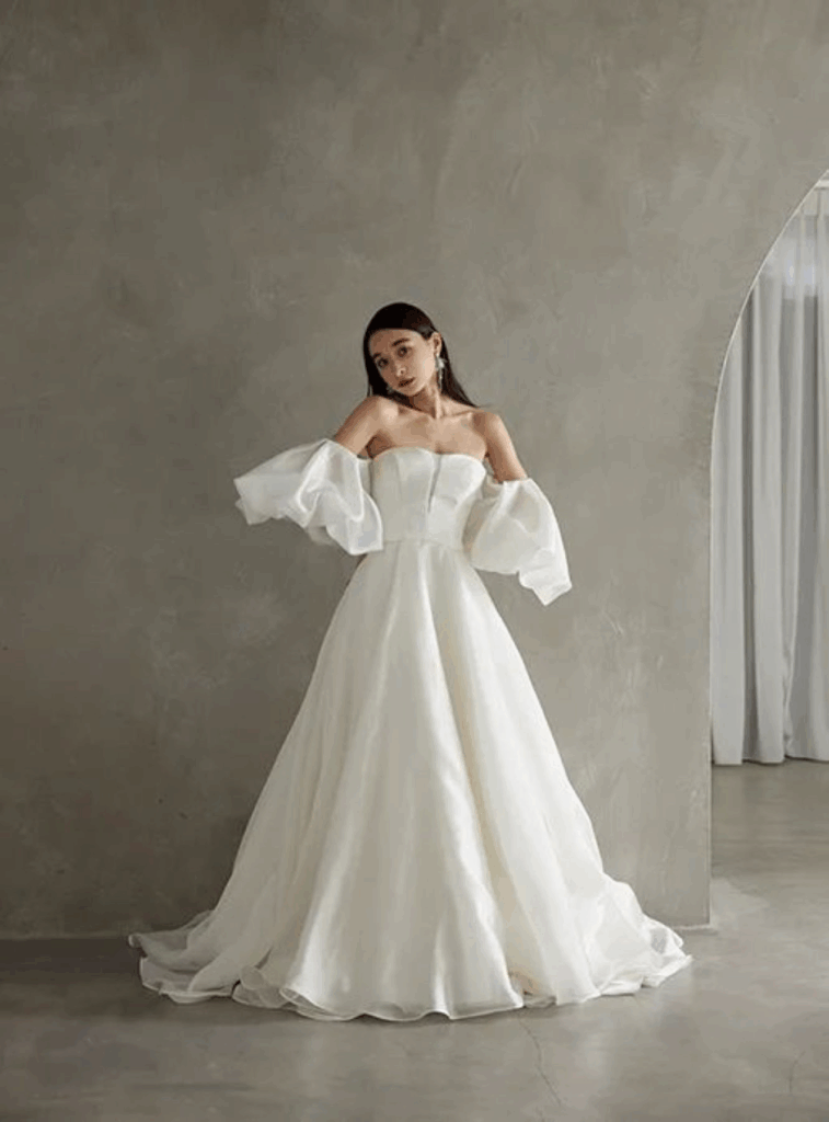 【さいたま市結婚式場アネーリ大宮】のスタイリッシュな空間に映える、パフスリーブが特徴的な最新ウェディングドレス。さいたま市にある市の式場で叶える、トレンドを意識した花嫁コーディネートを詳細に描写しており、さいたま市内での結婚式をよりお洒落に演出する一着を表現しています。