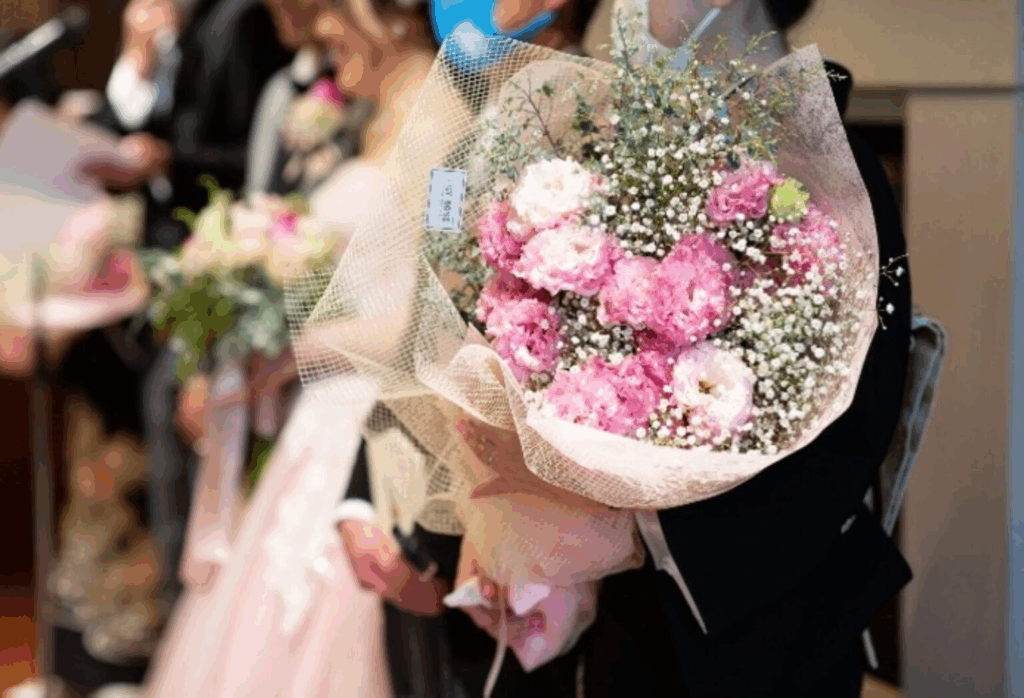 さいたま市結婚式場アネーリ大宮。結婚式の両親贈呈品。ピンクの花束を添えた、名前と生まれてからの日数が刻印された「子育て感謝状」のキャンバスボード。