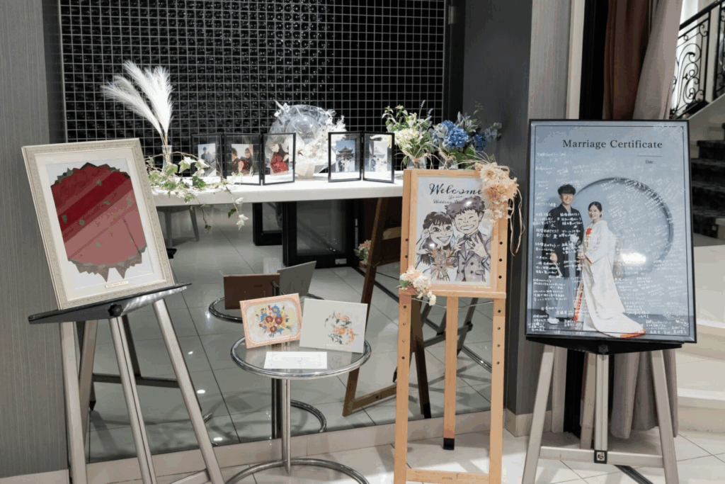 【さいたま市結婚式場アネーリ大宮】のロビーに飾られた、お洒落な似顔絵や和装姿の結婚証明書などのウェルカムアイテム。さいたま市にある市の会場で、お二人らしい世界観を詳細に描写しており、さいたま市内での結婚式に訪れるゲストを温かく迎えるおもてなしの空間を表現しています。