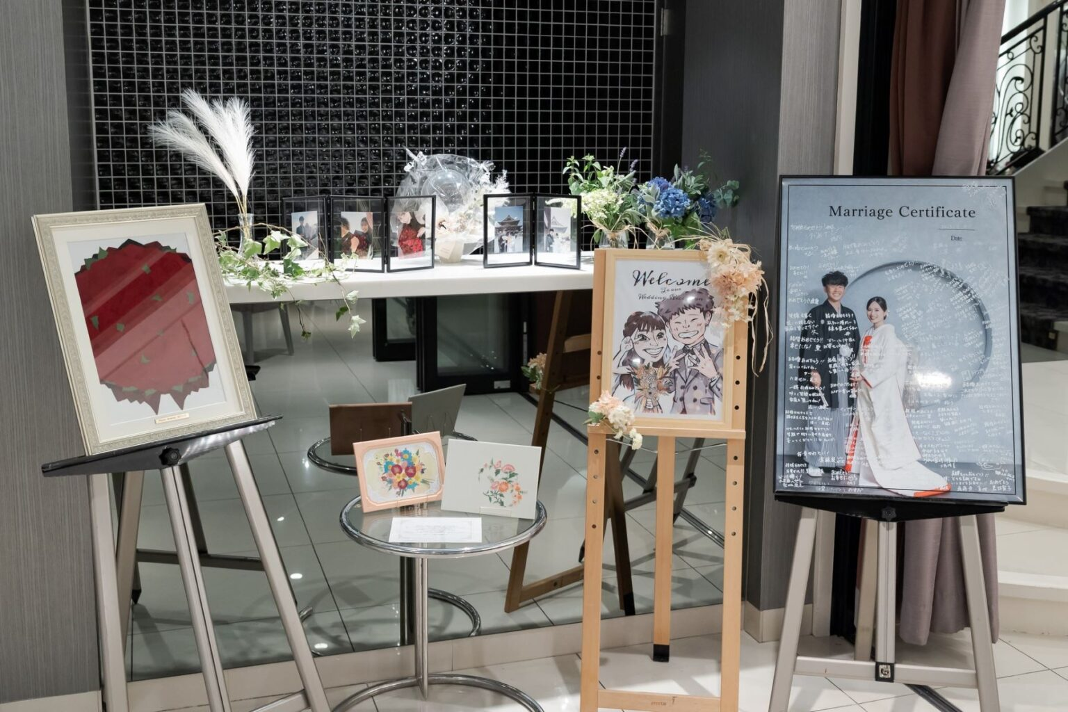 【さいたま市結婚式場アネーリ大宮】のロビーに飾られた、お洒落な似顔絵や和装姿の結婚証明書などのウェルカムアイテム。さいたま市にある市の会場で、お二人らしい世界観を詳細に描写しており、さいたま市内での結婚式に訪れるゲストを温かく迎えるおもてなしの空間を表現しています。
