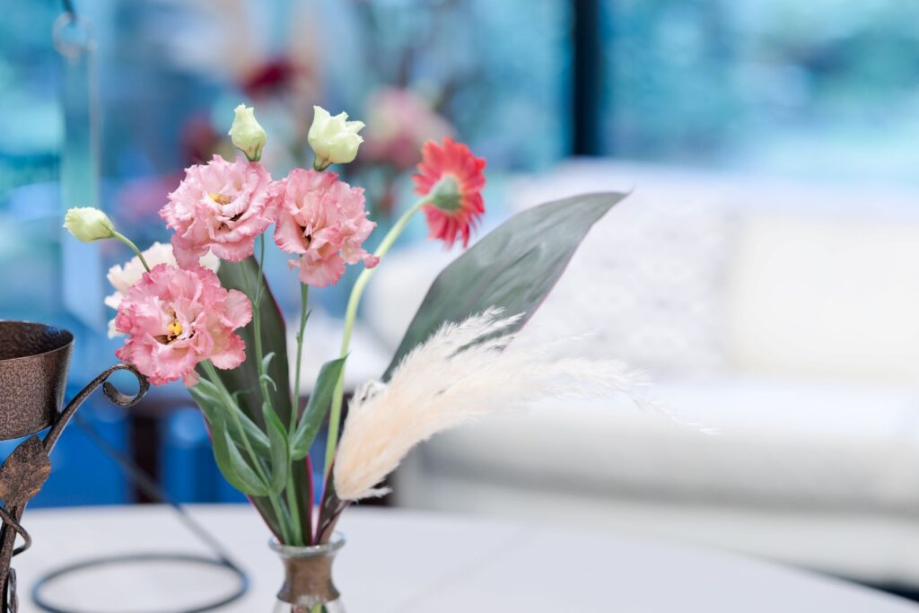 さいたま市結婚式場アネーリ大宮のラウンジを彩る、ピンクのトルコキキョウとパンパスグラスのフラワーアレンジメント。背景の明るいインテリアと調和する、ふんわりと優しい雰囲気の装花。