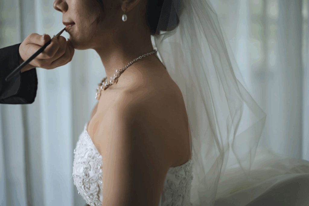 【さいたま市結婚式場アネーリ大宮】のブライズルームにて、プロの手で美しくメイクアップを仕上げる花嫁様。さいたま市にある市の中心部で叶える、特別な一日が始まる高揚感を詳細に描写しており、さいたま市内での結婚式を控えた花嫁様の純粋な美しさを引き立てています。