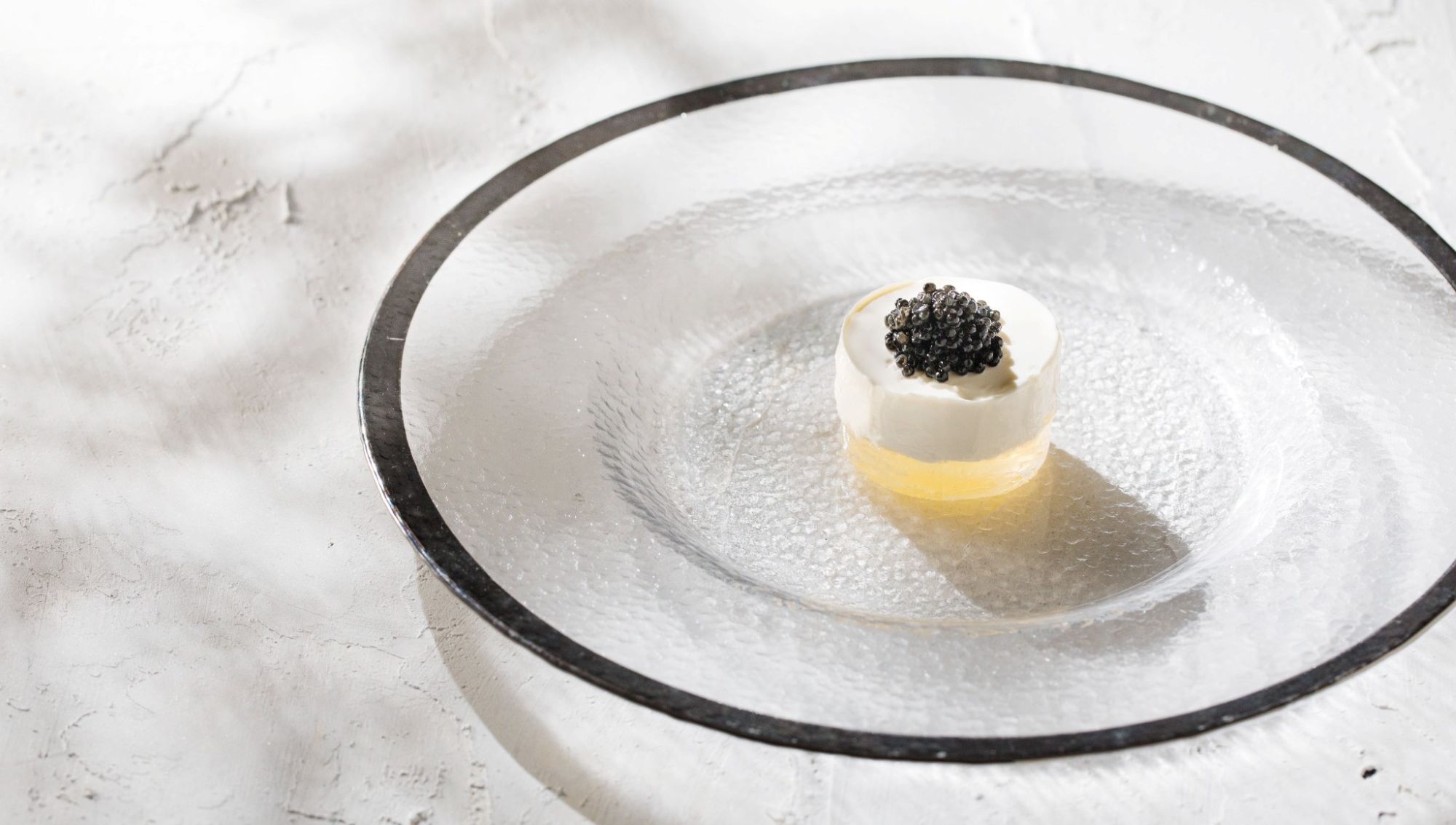 アネーリ大宮の婚礼料理。シルバーリムのガラス皿に盛り付けられた、キャビアを添えた白いムース。大宮の結婚式場で提供される、透明感と高級感あふれる本格フレンチの冷製前菜。