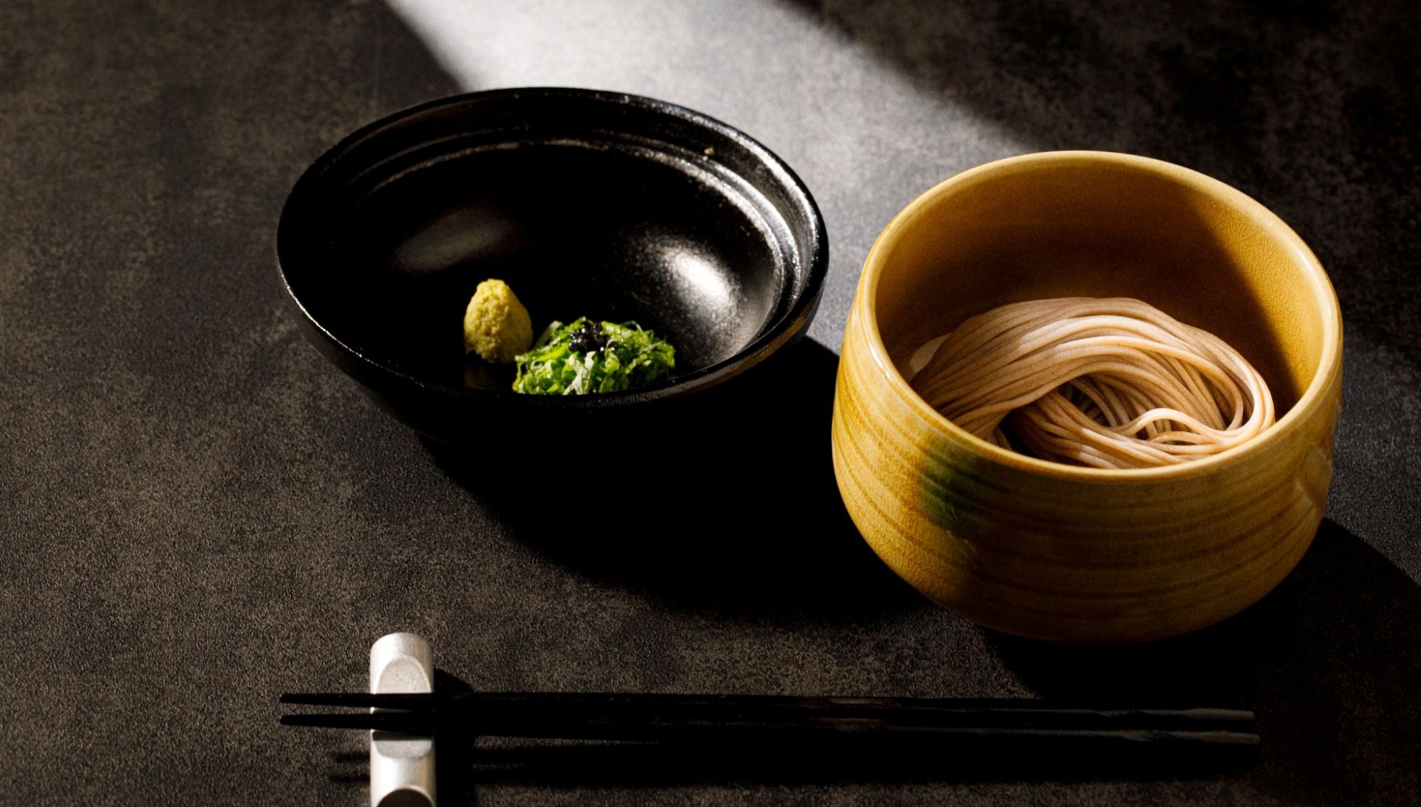 アネーリ大宮の和の婚礼料理。黄色い器に端正に盛り付けられた蕎麦と、黒い器に添えられた薬味のわさび。大宮の結婚式場でゲストに振る舞われる、コースの締めくくりにふさわしい本格的な和食メニューの一皿。