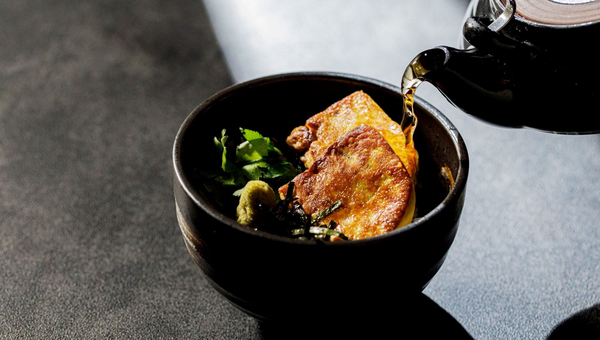 アネーリ大宮の婚礼料理。黒い椀に盛り付けられた香ばしいフォアグラのひつまぶしに、熱々の出汁を注ぐおもてなしの演出。大宮の結婚式場でゲストに親しまれる、和洋折衷の贅沢な締めの一皿。