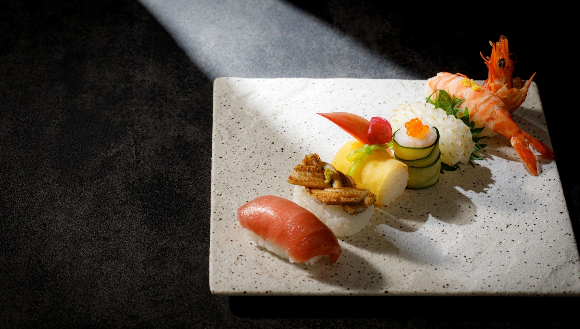 アネーリ大宮の婚礼料理。白磁の角皿に美しく並んだマグロ、穴子、海老などの色鮮やかな握り寿司。大宮の結婚式場でゲストに振る舞われる、お祝いの席を彩る華やかな和の逸品。