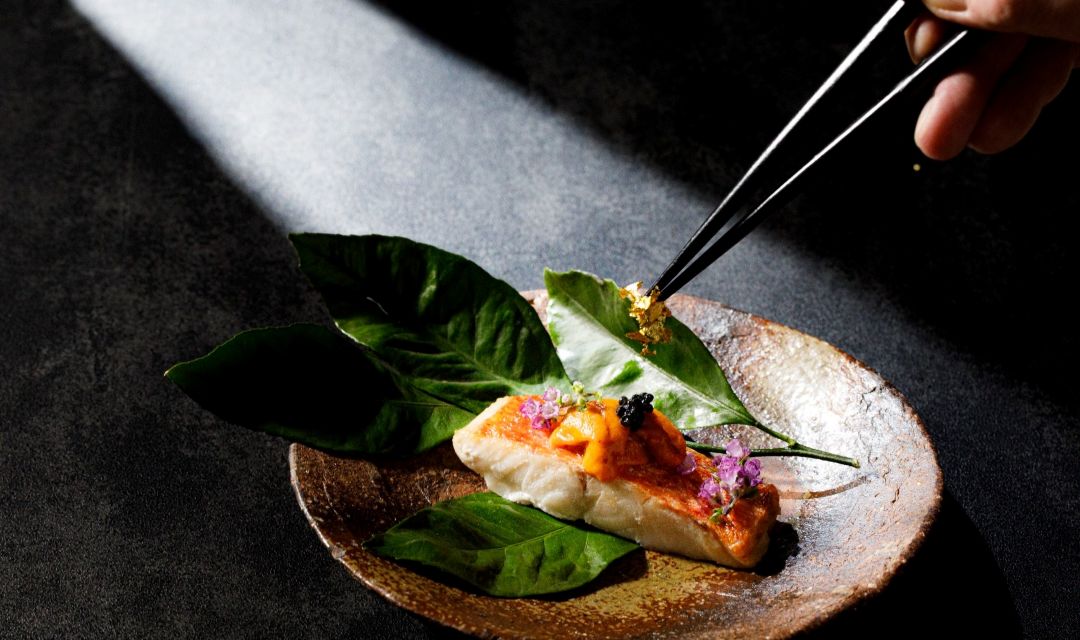 埼玉・大宮の結婚式場アネーリ大宮の和食。金目鯛とウニの贅沢な一皿に、シェフが金箔を添えて仕上げる調理シーン。